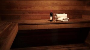 Un banc en bois sur lequel sont posés une bouteille de vin et un verre.