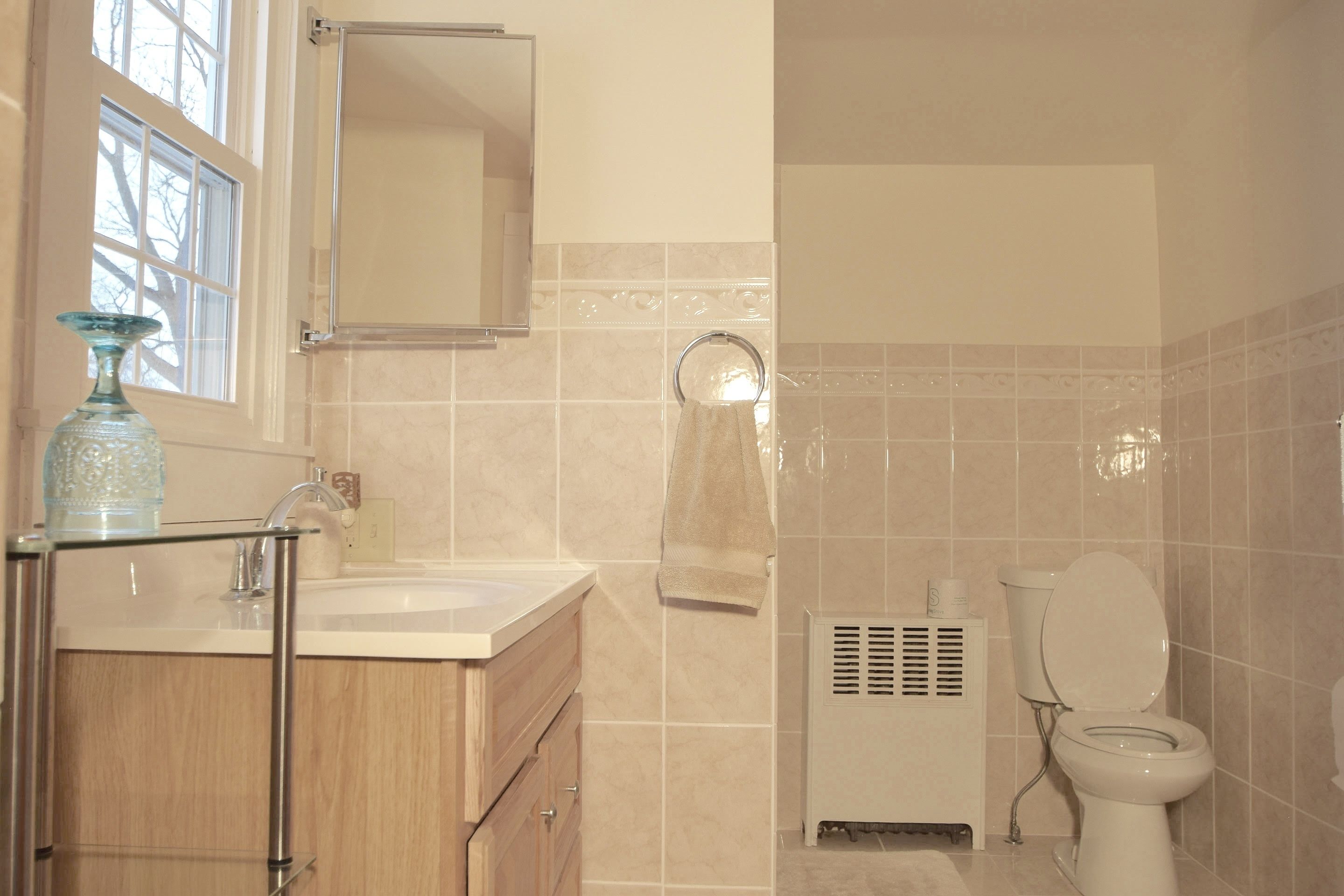 Une salle de bain équipée d’un lavabo, d’un miroir, d’un porte-serviettes et de toilettes.