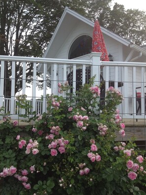 Un bâtiment blanc avec un porche et un parasol rouge.