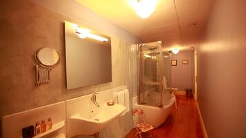 Un baño moderno con un espejo grande, dos lavamanos, una bañera y una ducha.