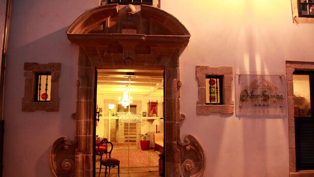 Une entrée surmontée d’une arche en pierre qui mène à un intérieur chaleureux et bien éclairé.