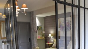 Une chambre à coucher avec un lit, un banc, une table de chevet, une lampe et un miroir.