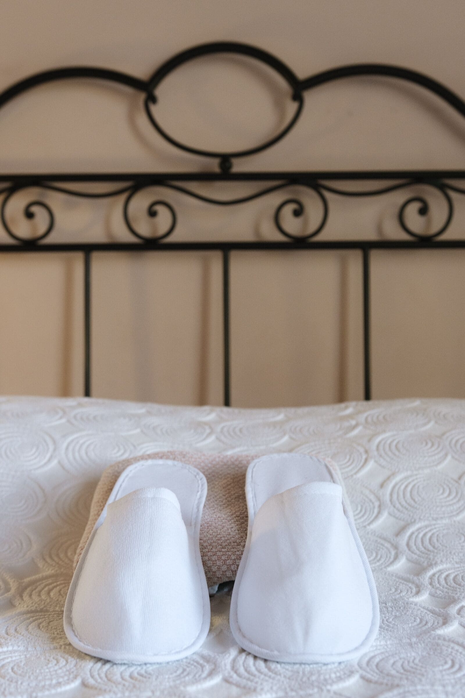 A bed with a metal headboard and a white pillow.