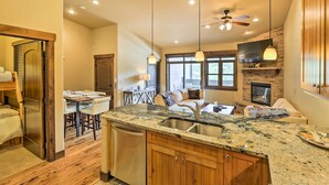 A modern kitchen with granite countertops, wooden cabinets, and a built-in dishwasher. - Elegant Frisco Condo w/ Private Hot Tub & Views! (Frisco)