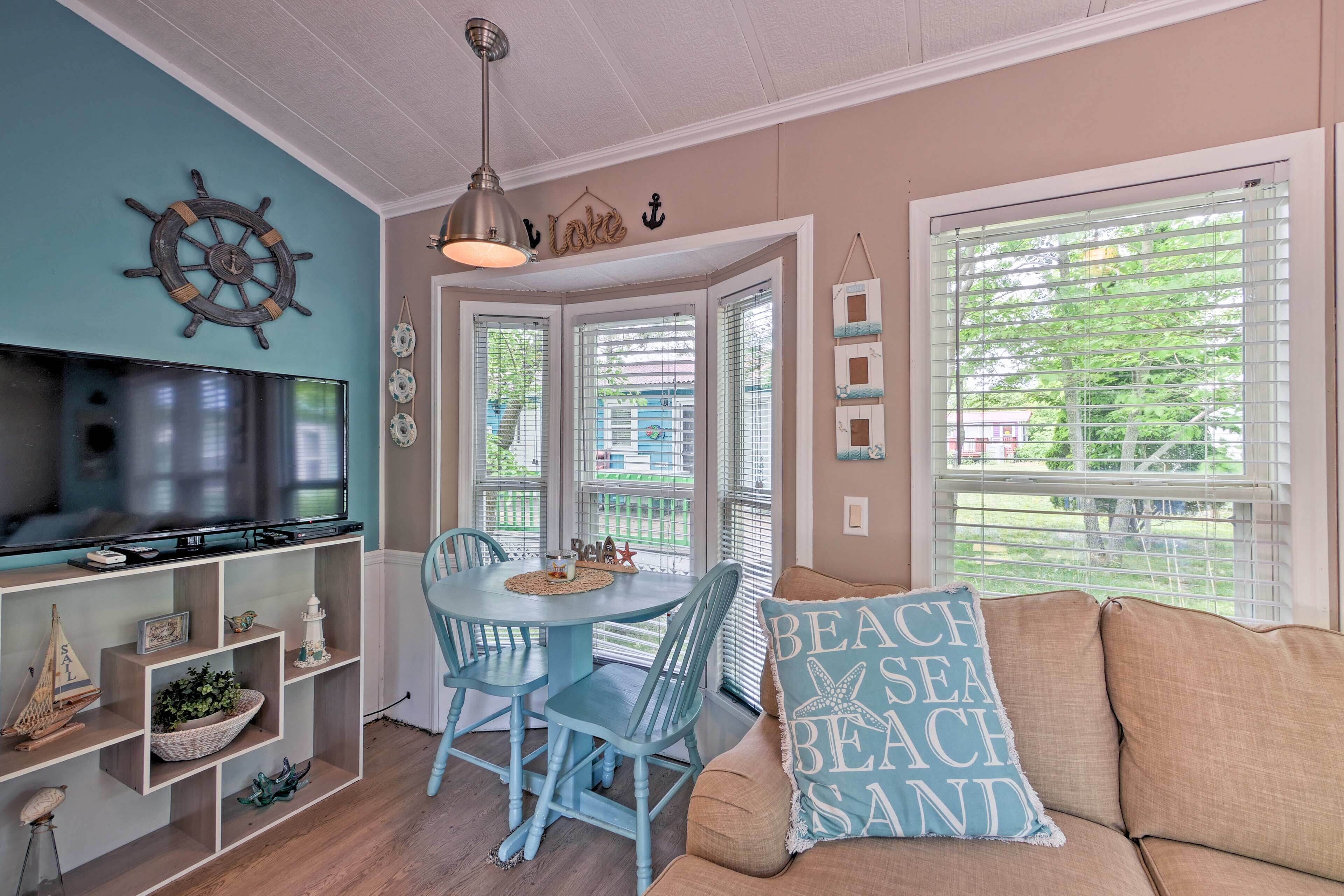 A cozy living room with a television, a dining table, and a sofa.