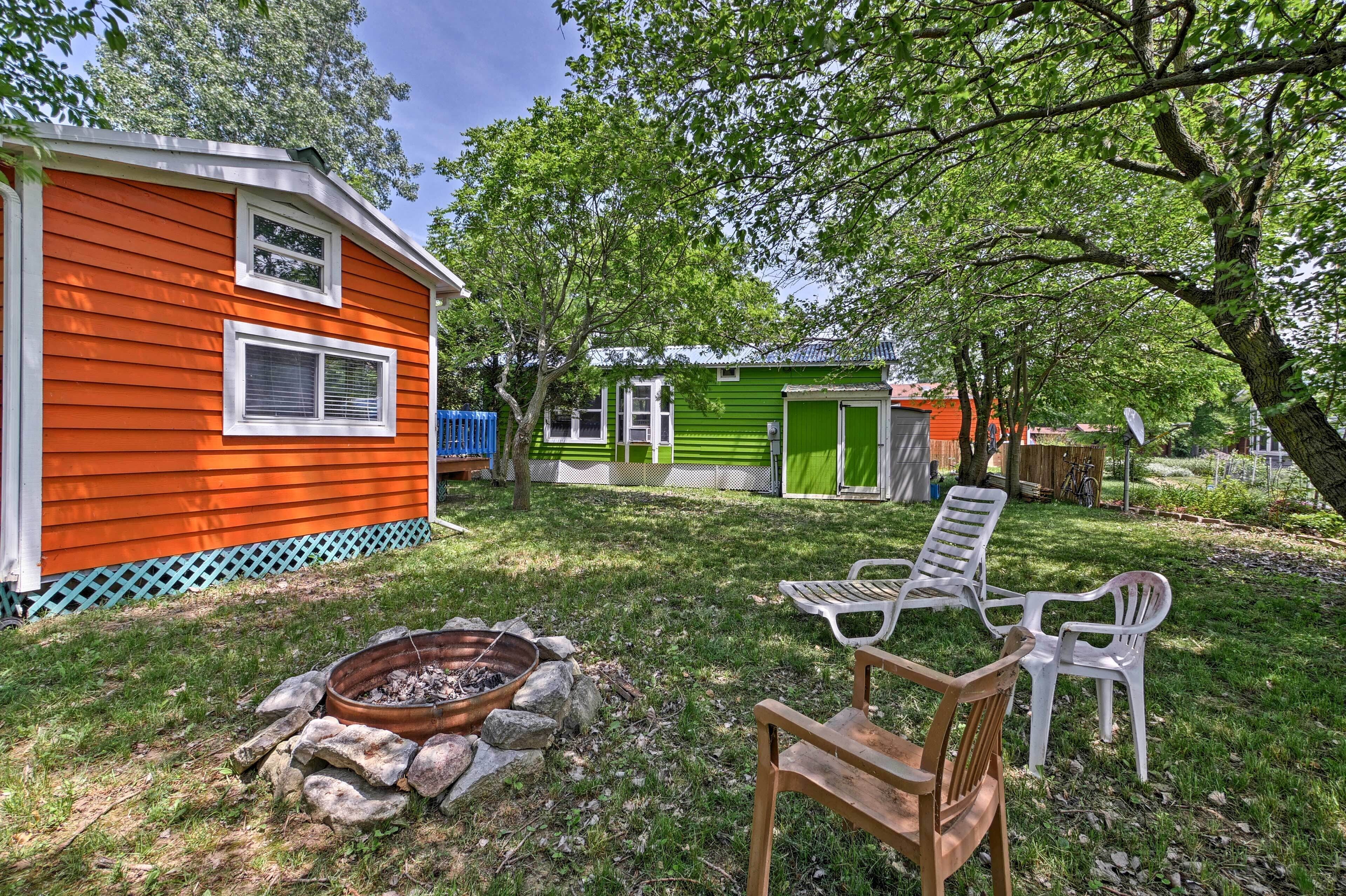 A recreational area with a fire pit, outdoor seating, and a small shed.