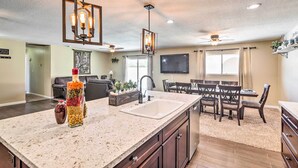 A modern kitchen with a large island, built-in appliances, and pendant lighting. - Lake Havasu Home w/ Pool, Near London Bridge! (Lake Havasu City)