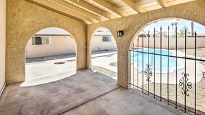 A covered patio area with a pool, featuring arched openings and a concrete floor. - Lake Havasu Home w/ Pool, Near London Bridge! (Lake Havasu City)