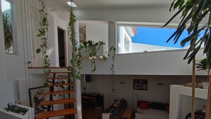 Un espacio habitable moderno con una escalera de madera, un sofá y una mesa de centro.