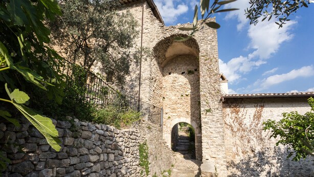 A stone pathway leading through an arched doorway in a rustic stone building. - LE ROCCHE - Under the Castle, SMERALDO Apartment with SPA and Black River View (Ferentillo)