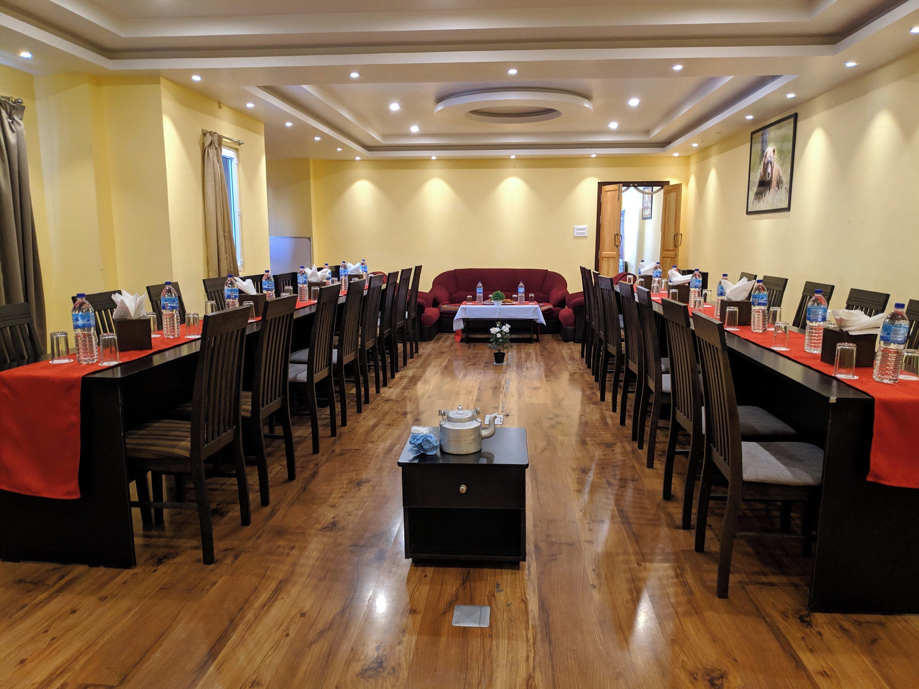 A conference room with a long table, chairs, and a sofa.