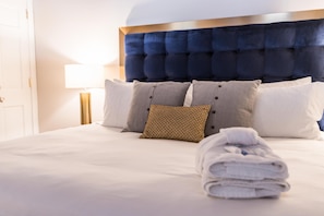Restful retreat with a large bed and plush pillows, complete with a bedside table and lamp.