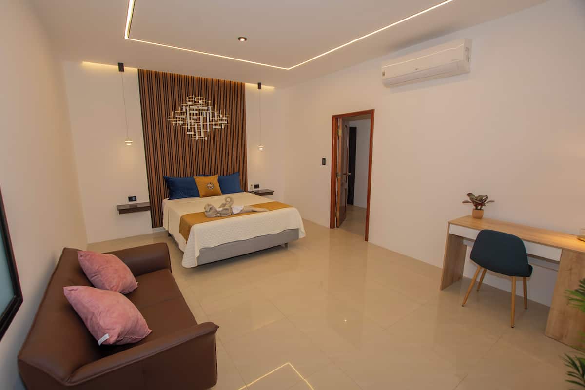 Une chambre à coucher moderne avec un lit, un bureau et un canapé.