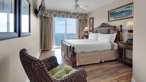 A hotel room with a bed, a chair, a nightstand, a lamp, a painting, and a view of the ocean. - VIEWS TO BEACHES & RUSSELL-FIELDS PIER!BCH SRVC INCL!! (Panama City Beach)