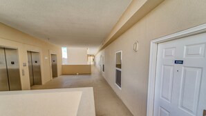 A hallway with multiple elevators and a door marked 2103.