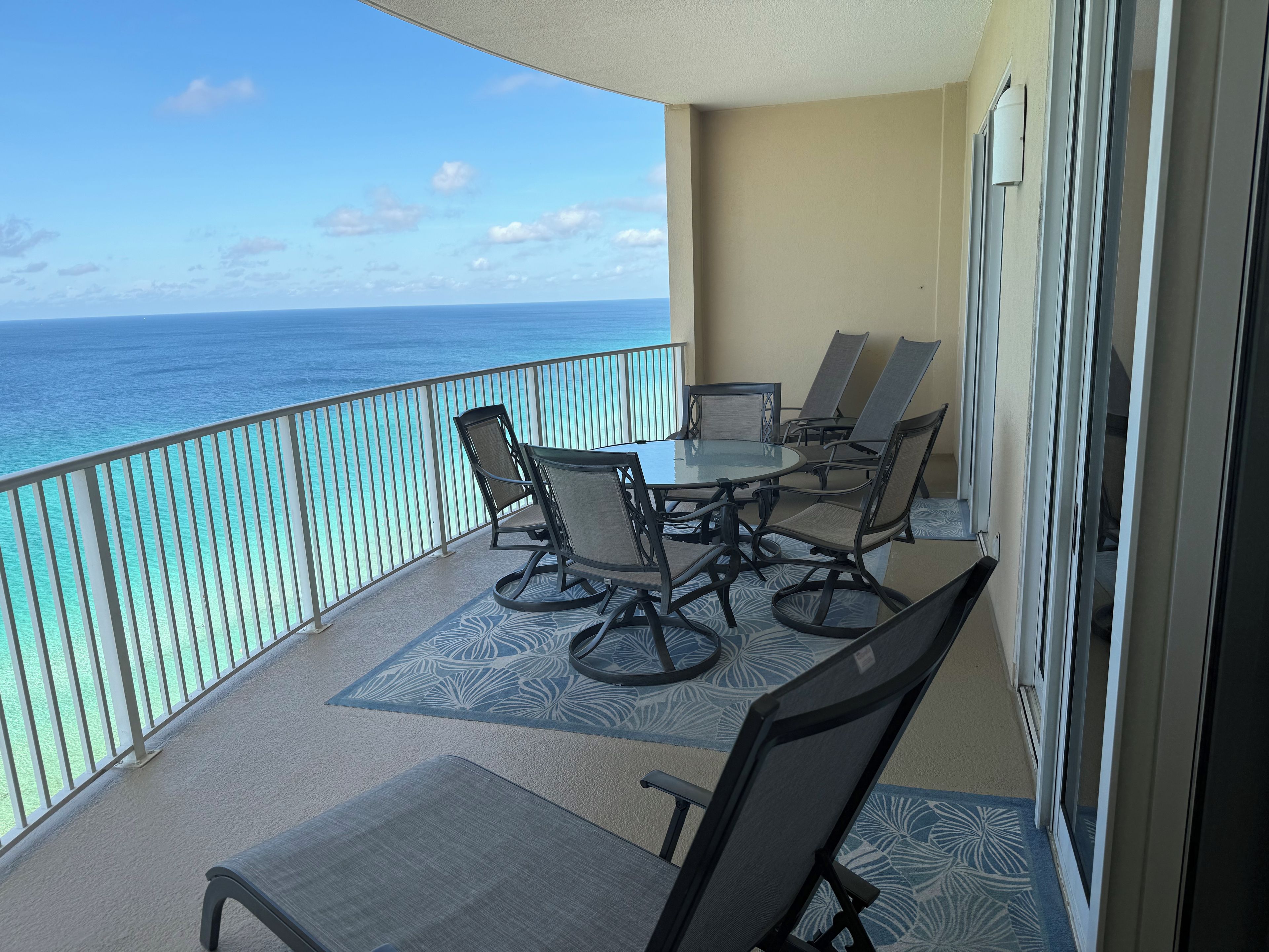 Un balcone con tavolo e sedie, vista sull'oceano.