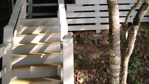 A wooden staircase leading up to a building with white railings, surrounded by trees. - Exclusive Smith Lake Slice of Heaven  in the Gated Point William Development.  (Crane Hill)