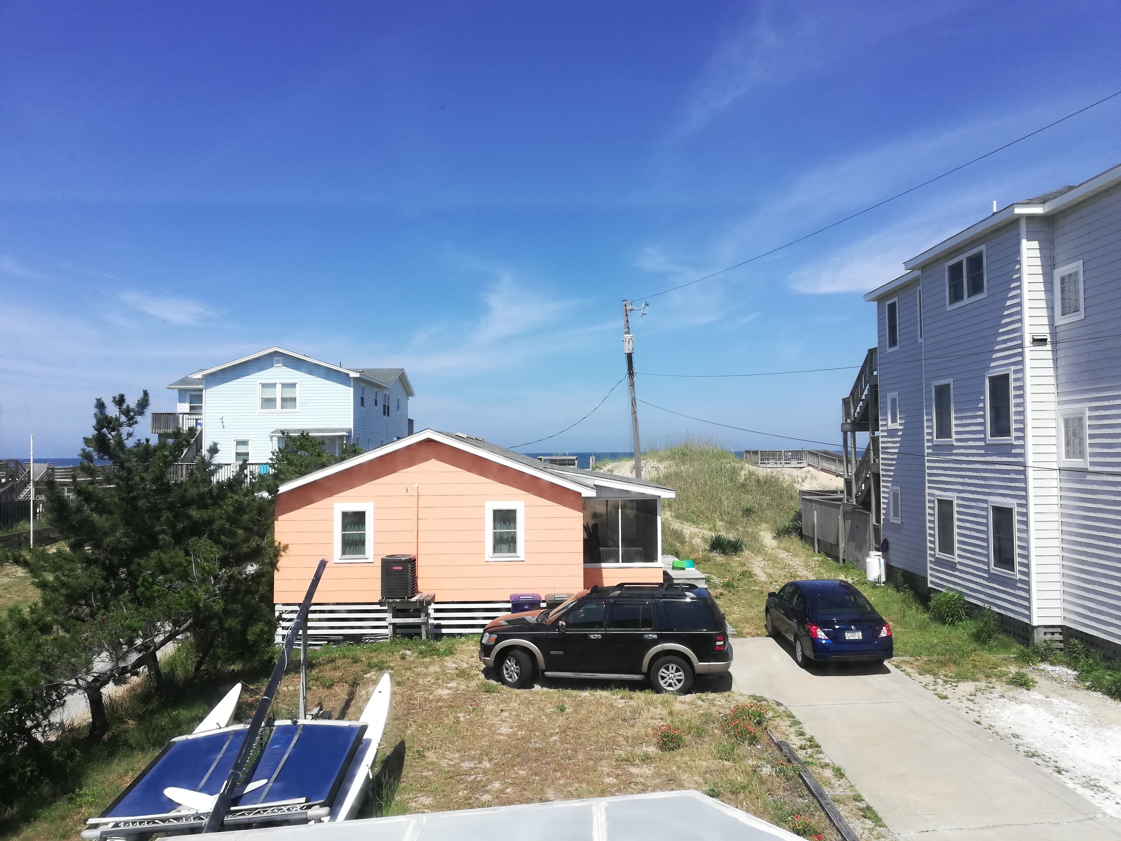 A residential area with houses, a parked SUV, and a boat.