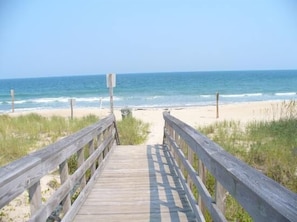 A wooden boardwalk leading to a beach with the ocean in the background. - JULY 4TH SPECIAL-Huge Seaside Porch Near Pier, HAMMOCK,OCEANFRONT,STEPS TO BEACH (Kure Beach)