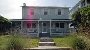 Una casa a due piani con veranda e vialetto in ghiaia, con il numero '341' ben visibile.