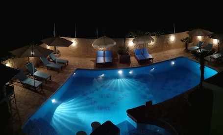 Una piscina al aire libre, sombrillas, sillones reclinables de piscina. Guest House Kithairon