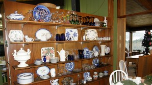 A display of various ceramic dishes and glassware on wooden shelves. - Berkshire Mountain House (Stephentown)