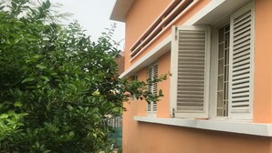 Un bâtiment doté d’un toit plat, d’un balcon et d’une fenêtre avec des volets.