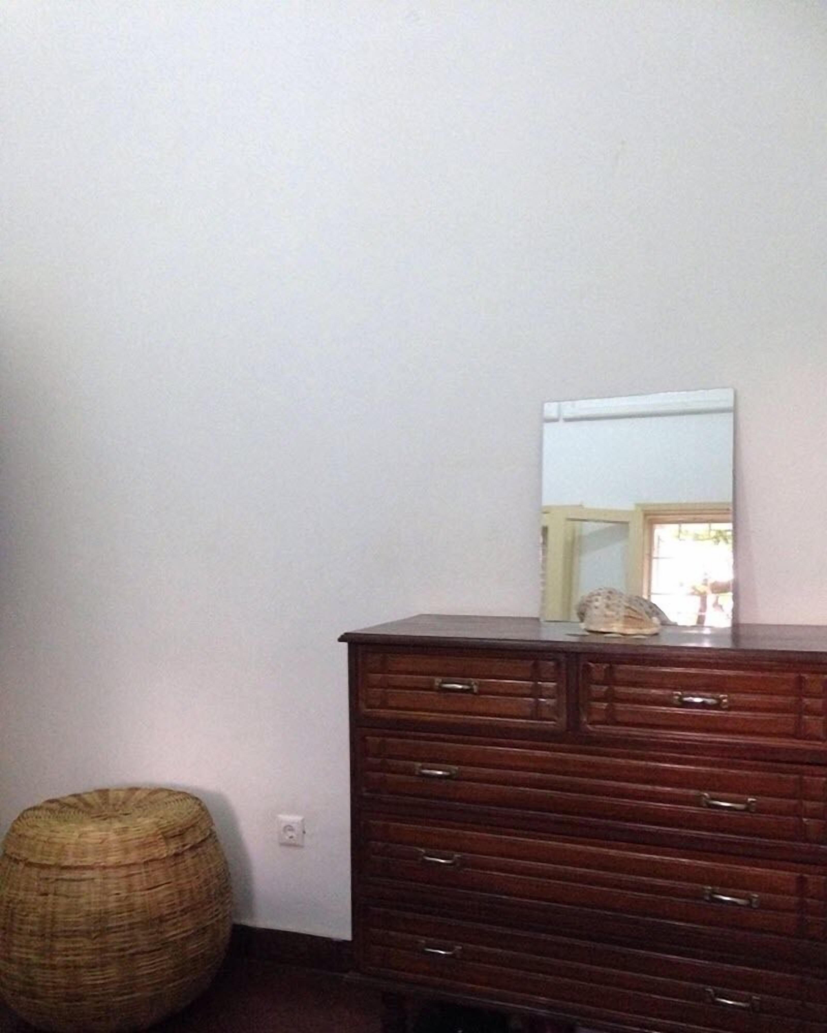 Een houten dressoir met lades en een spiegel.