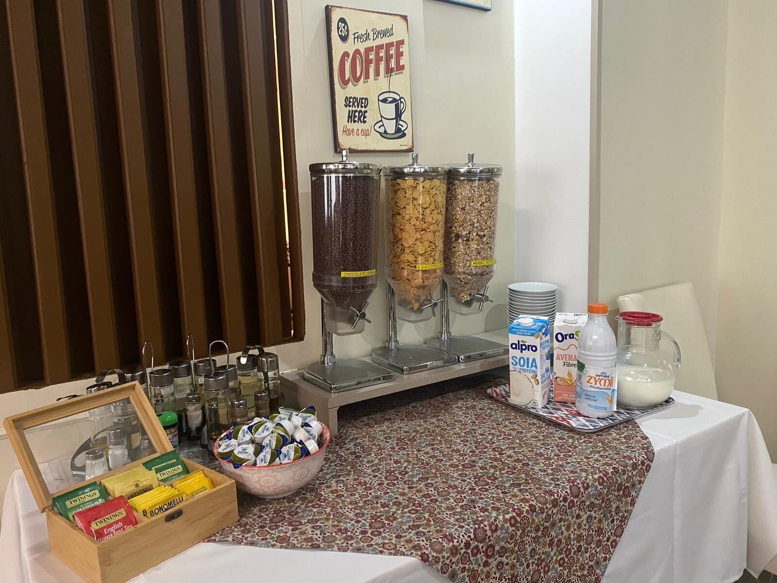 A breakfast bar with coffee, cereal, and milk options.
