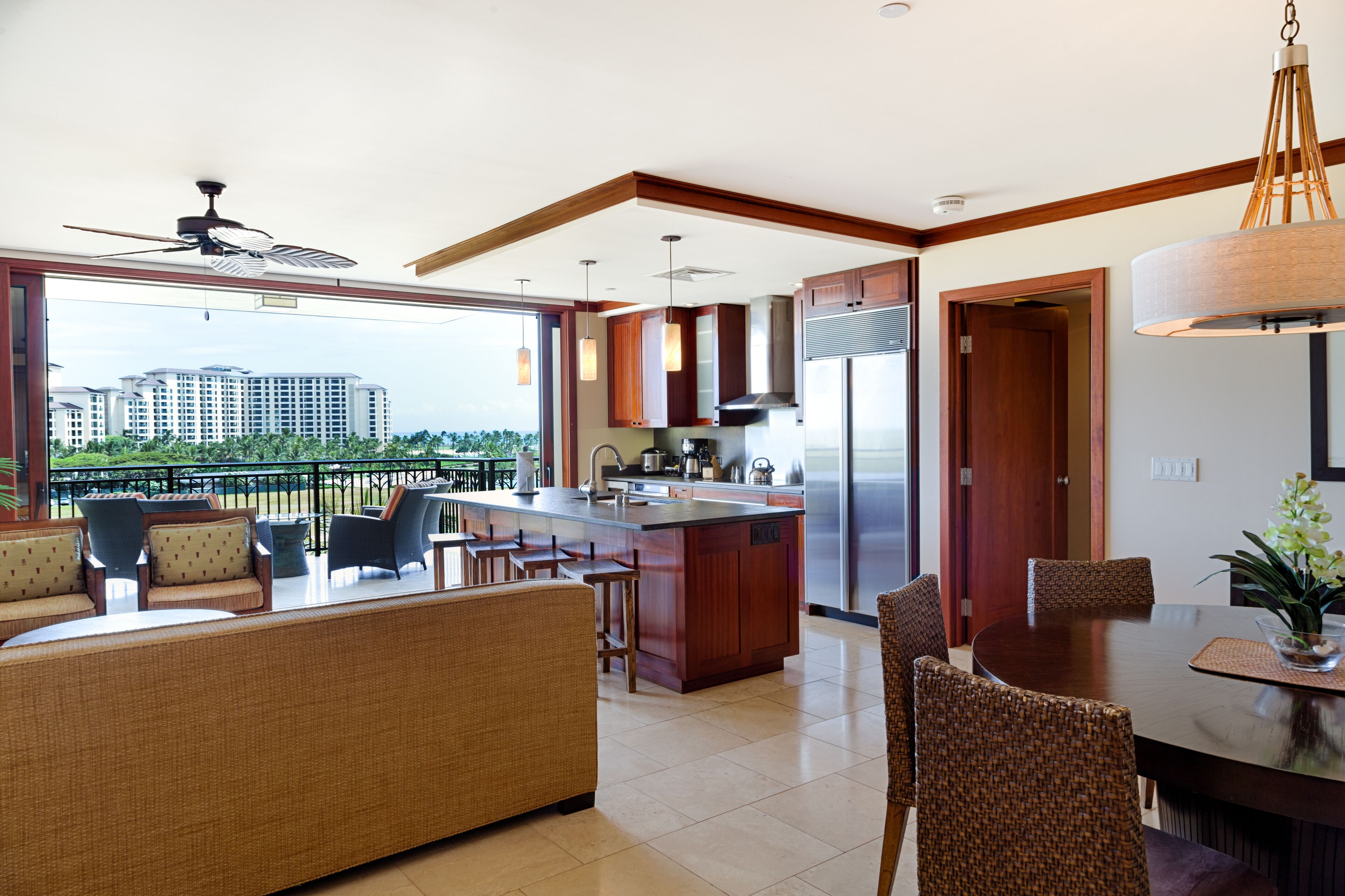 A modern kitchen with a large island, bar stools, and a dining area with a round table and chairs.