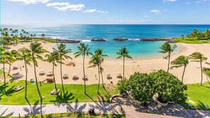 A beach resort with a clear view of the ocean, palm trees, and a paved walkway leading to the beach. - The Beach Villas at Ko Olina by Real Select Vacations (Kapolei)