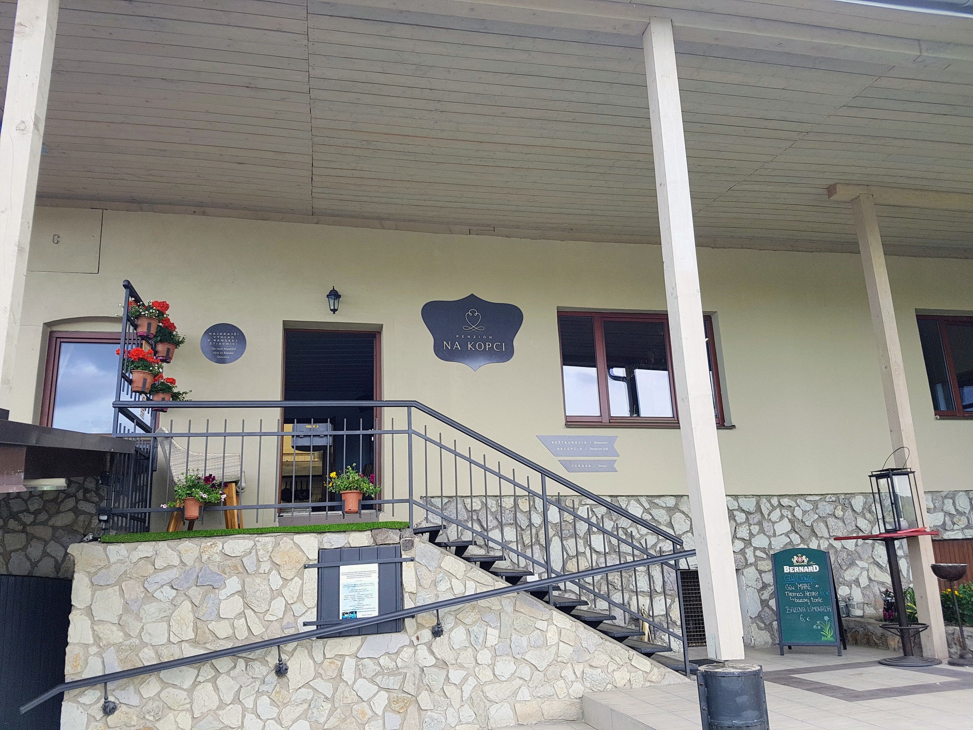 A building with a stone facade, a staircase with metal railings, and a sign indicating a restaurant named "Bernard."
