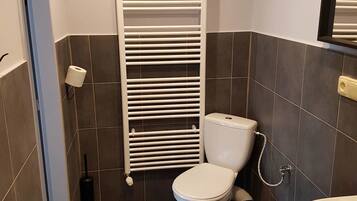 Un baño pequeño con inodoro, bidé y lavamanos.