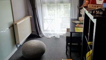 Cozy playroom with a large window, radiator, and soft seating area.