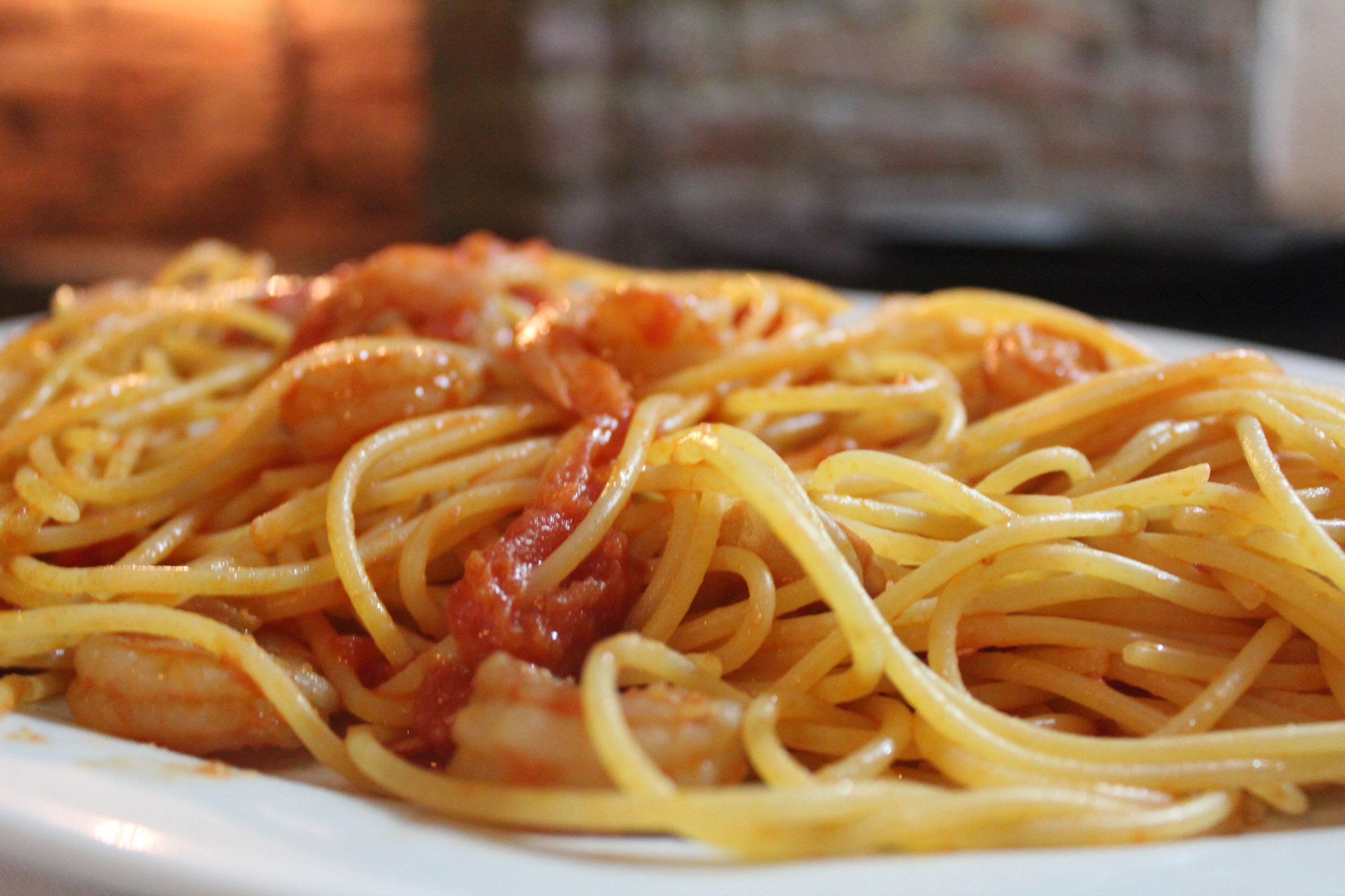 A plate of spaghetti with tomato sauce and shrimp.