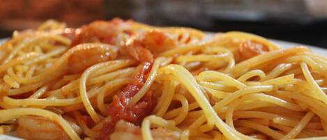 A plate of spaghetti with tomato sauce and shrimp.