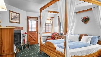 A four-poster canopy bed with white bedding, a wooden headboard, and a green patterned carpet.