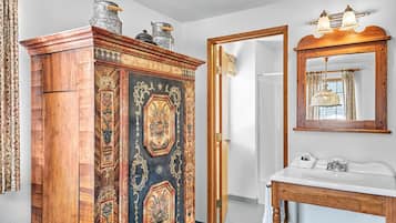 A room with a wooden cabinet, a mirror, and a white sink.