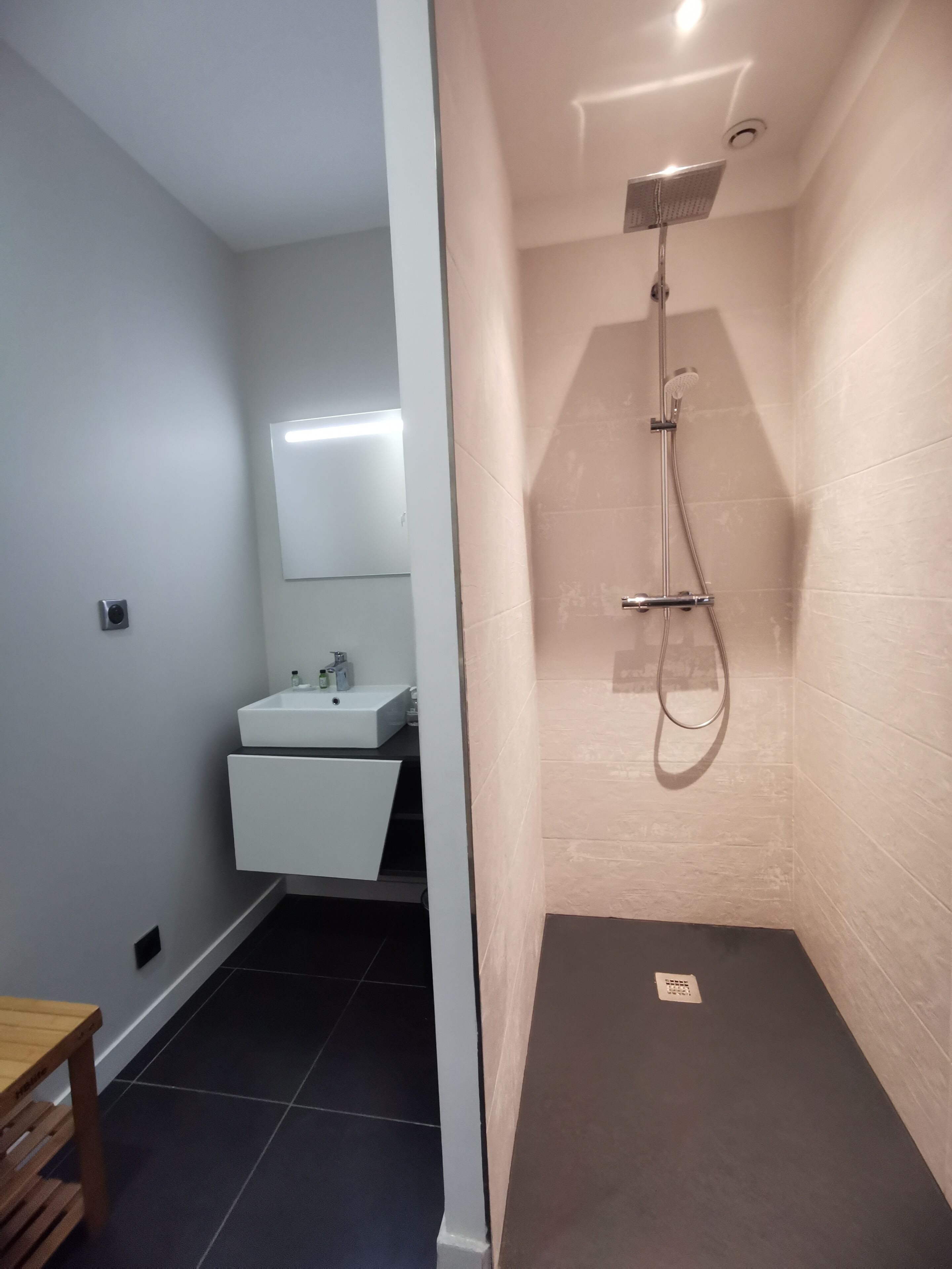 A bathroom with a shower, a sink, and a mirror.