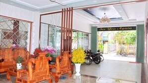 A reception area with a wooden reception desk, a large mirror, and a sign that reads "See You Again". - Khach San Yen Phu (Tuy Hoa)