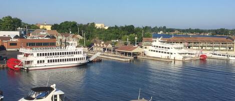 A marina with various boats docked, a large white boat labeled 'Uncle Sam Boat Tours,' and buildings in the background.