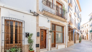 A narrow street lined with buildings featuring balconies, wooden doors, and potted plants. - House of 200 square meters in the historic center of Javea (Jávea)