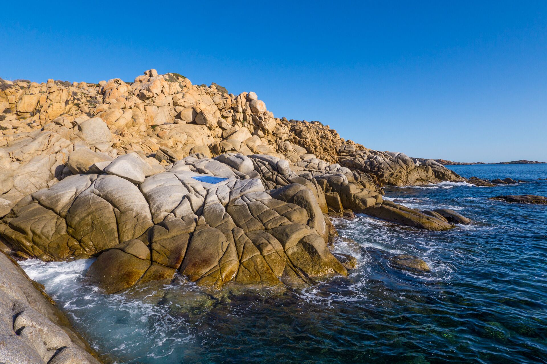 A rocky coastline with clear blue waters.