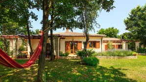 A house with a garden, a hammock, and a stone wall.