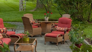 Relax in a serene outdoor space with wicker furniture, lush plants, and a tranquil garden.