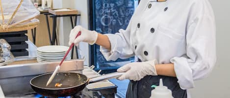 A chef cooking in a kitchen with a bowl of eggs in the foreground.