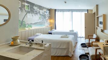 Relax in a serene space with two single beds, a wall mural, and a marble bathroom.