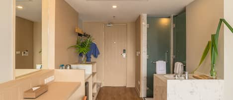 A modern bathroom with a wooden vanity, a mirror, and a shower area.