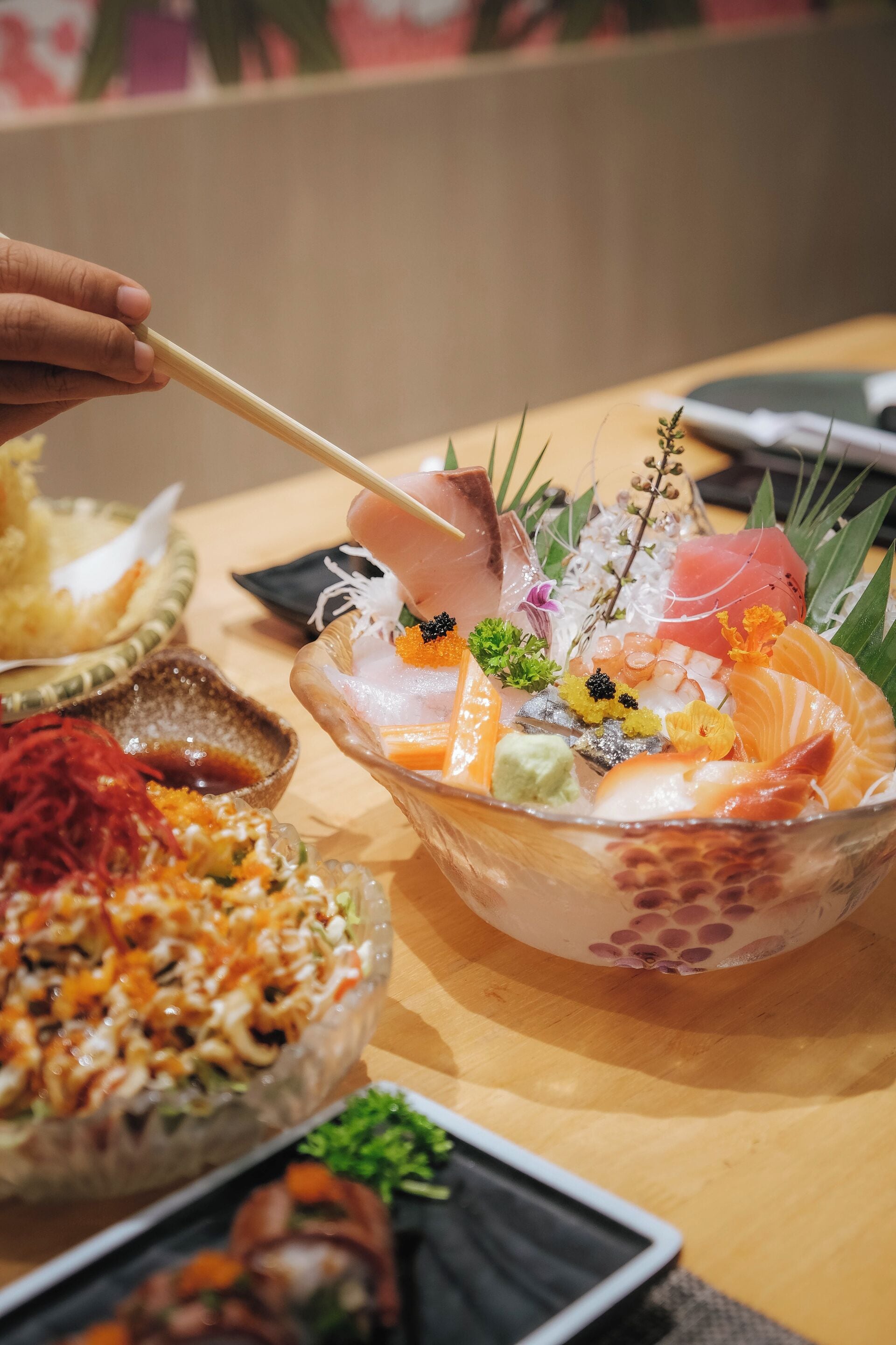 Una bandeja de sushi con diferentes tipos de pescado y guarniciones.