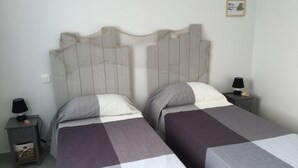 A double bed with a headboard, two bedside tables with lamps, and a small framed picture on the wall. - Bassin d'arcachon, a cozy little nest between dune du pyla and cap-ferret  (Audenge)